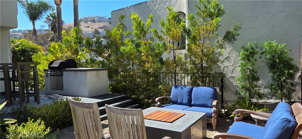 Firepit, lounges, and chairs all set against a lush hillside backdrop - 106 Avenida Mesita, San Clemente CA 92673 - photo 17