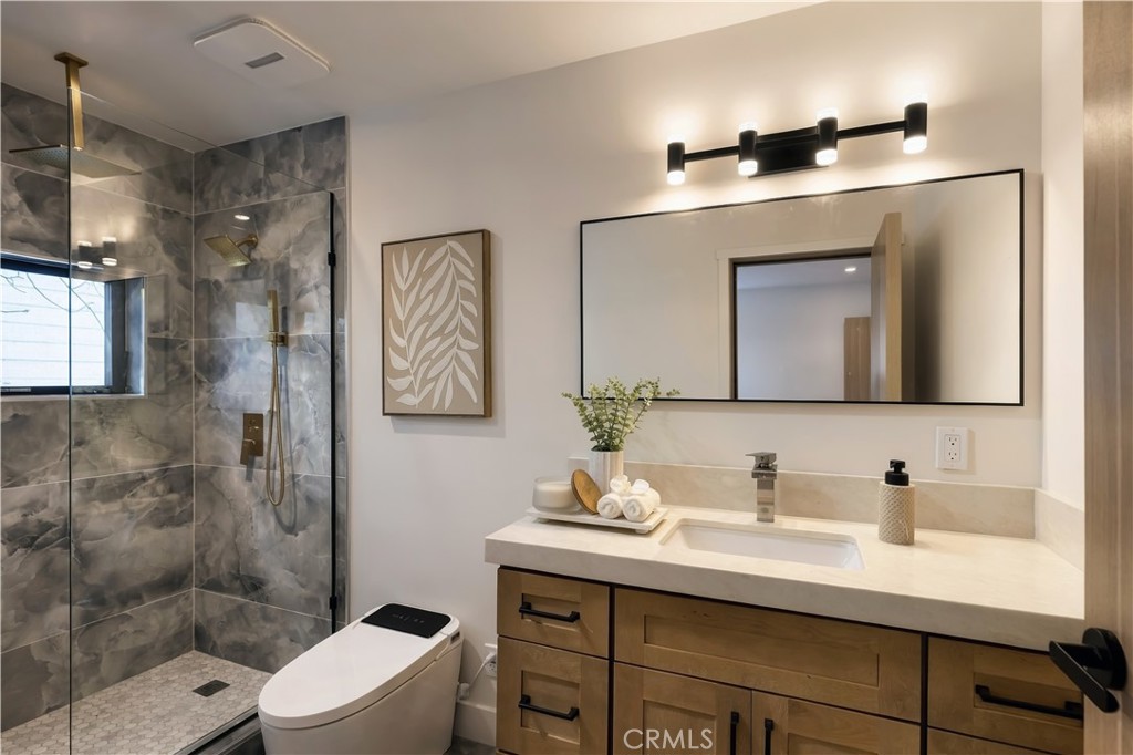 Guest suite bath: Charcoal onyx-look stone, brushed-gold rain head and handheld wand, and a window in the shower. - 126 Calle Redondel, San Clemente CA 92672 - photo 33