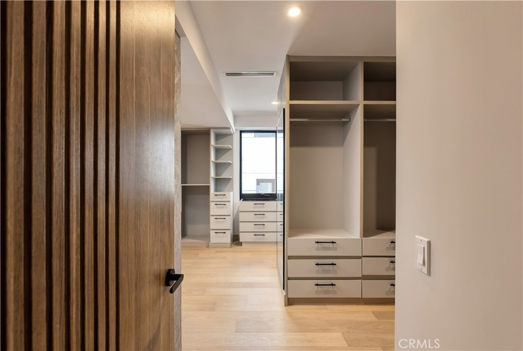 Dressing room entry: Custom built-ins revealed behind a fluted wood door. - 126 Calle Redondel, San Clemente CA 92672 - photo 46