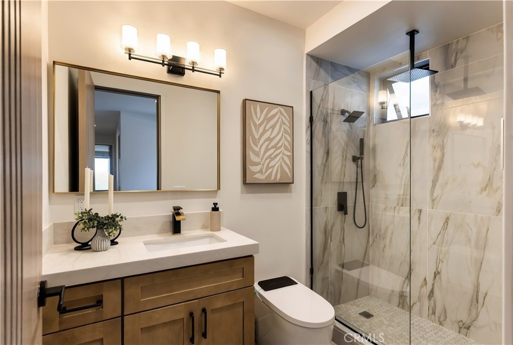 Secondary Bath:Walk-in shower with rain head and handheld wand, warm-veined stone, and a clerestory window. - 126 Calle Redondel, San Clemente CA 92672 - photo 56