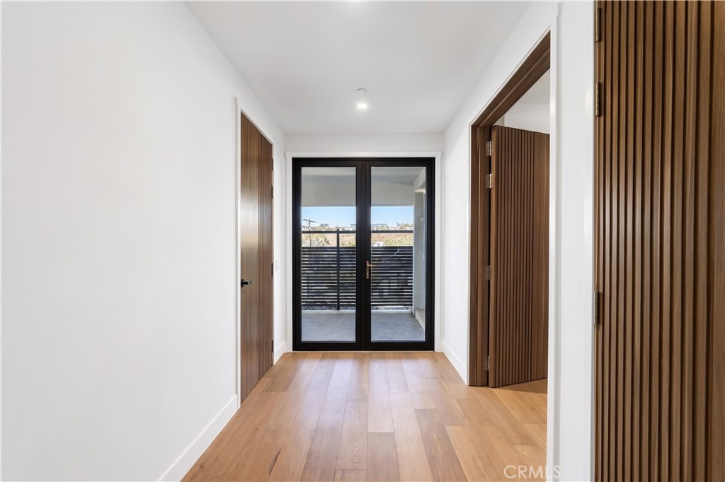 Wide halls and fluted wood doors lead to glass doors and a covered terrace. - 126 Calle Redondel, San Clemente CA 92672 - photo 57