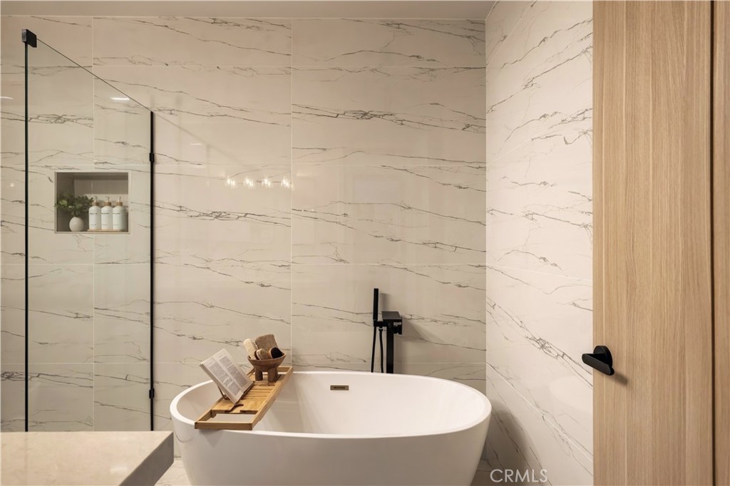 Freestanding soaking tub with floor-mounted filler, set against marble-look walls. - 126 Calle Redondel, San Clemente CA 92672 - photo 61