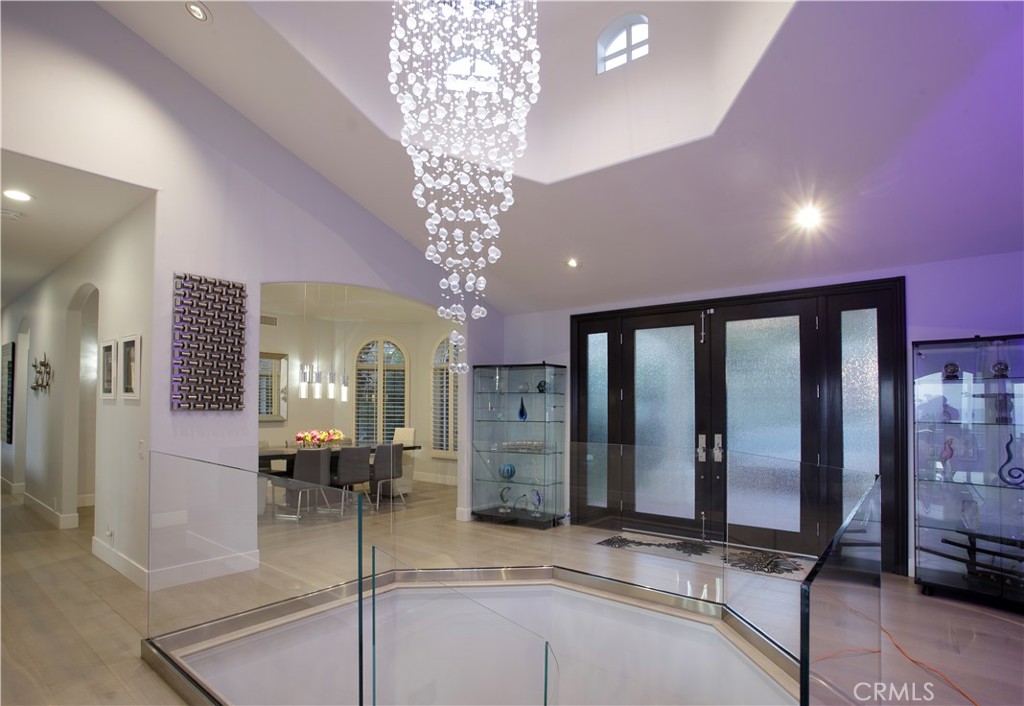A dramatic two-story foyer introduces the residence, where a cascading crystal chandelier, contemporary glass stair rail - 3 Via Pasa, San Clemente CA 92673 - photo 3