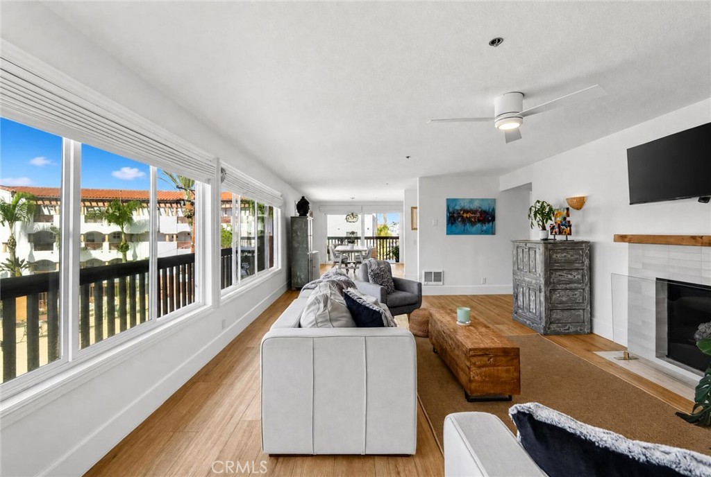Sunlight pours in from a wall of windows in the entire living area. - 409 Arenoso 2, San Clemente CA 92672 - photo 5