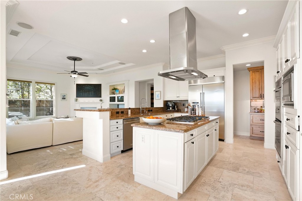 Stunning kitchen featuring white cabinetry, a center island, double ovens and counter seating. - 6614 Colina Puesta, San Clemente CA 92673 - photo 12