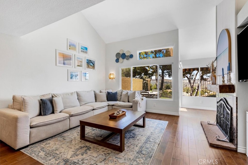 Living room with gas fireplace, soaring ceilings, and slider to backyard. - 27355 Paseo Laguna, San Juan Capistrano CA 92675 - photo 3
