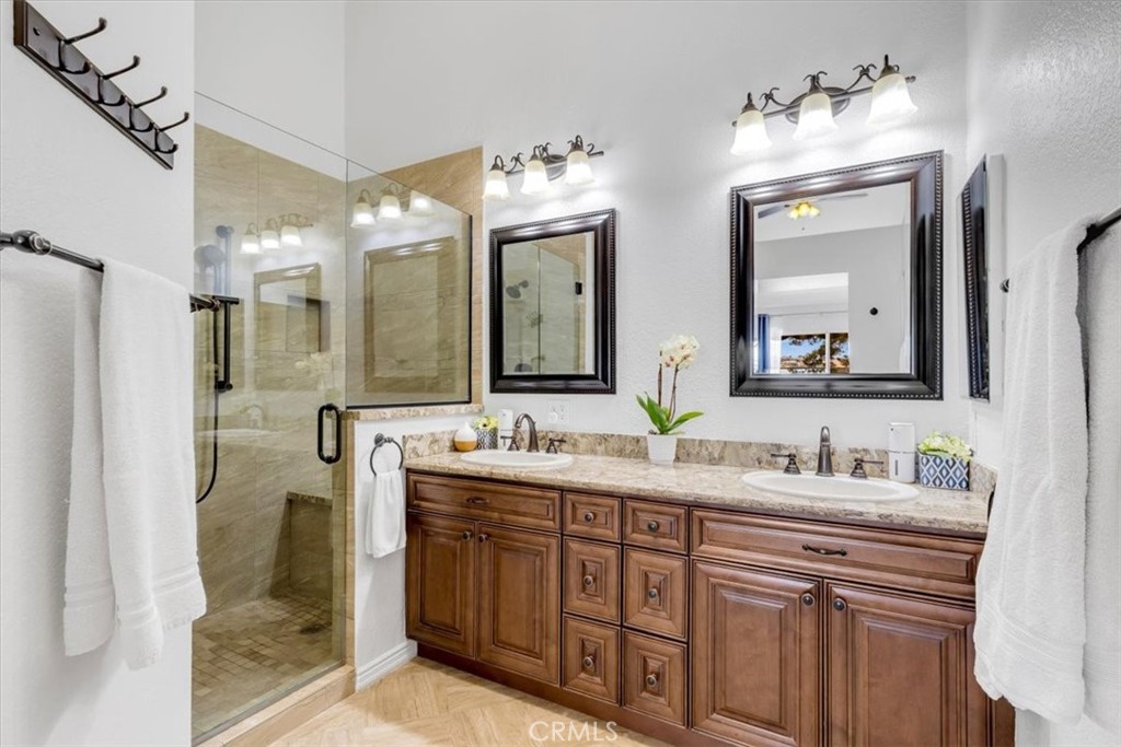 Primary bathroom has been beautifully upgraded and includes dual sinks and a step-in shower with custom tile. - 27355 Paseo Laguna, San Juan Capistrano CA 92675 - photo 24
