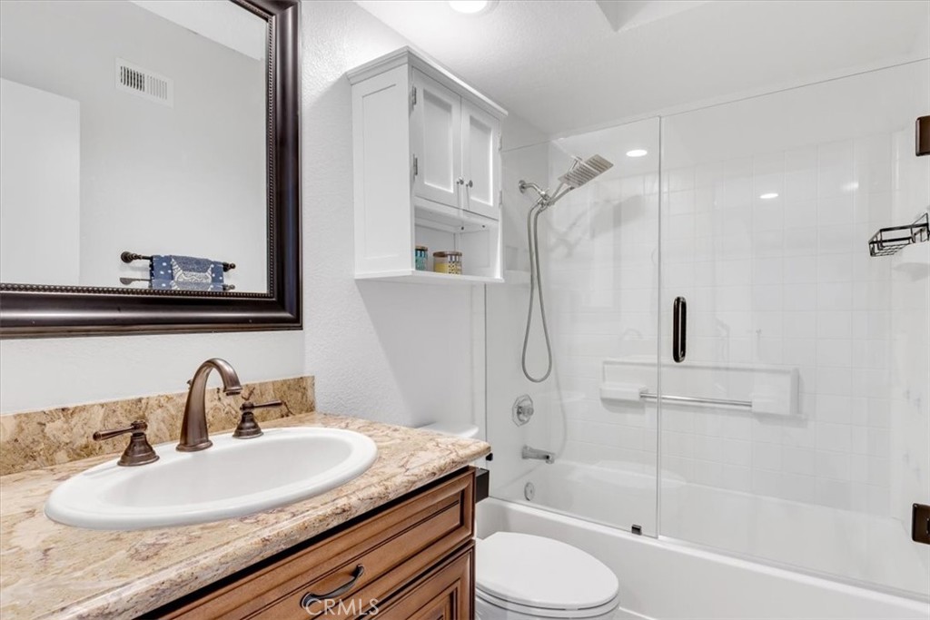 Adjacent to the second bedroom is the guest bathroom with beautiful granite topped vanity and glass enclosed shower/tub - 27355 Paseo Laguna, San Juan Capistrano CA 92675 - photo 28