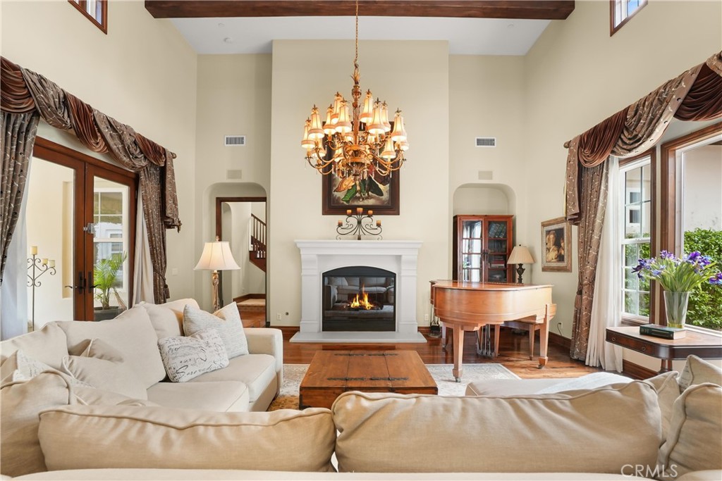 Dramatic great room with soaring ceilings, exposed wood beams, rich hardwood flooring, and elegant architectural details - 27532 Calle De La Rosa, San Juan Capistrano CA 92675 - photo 4