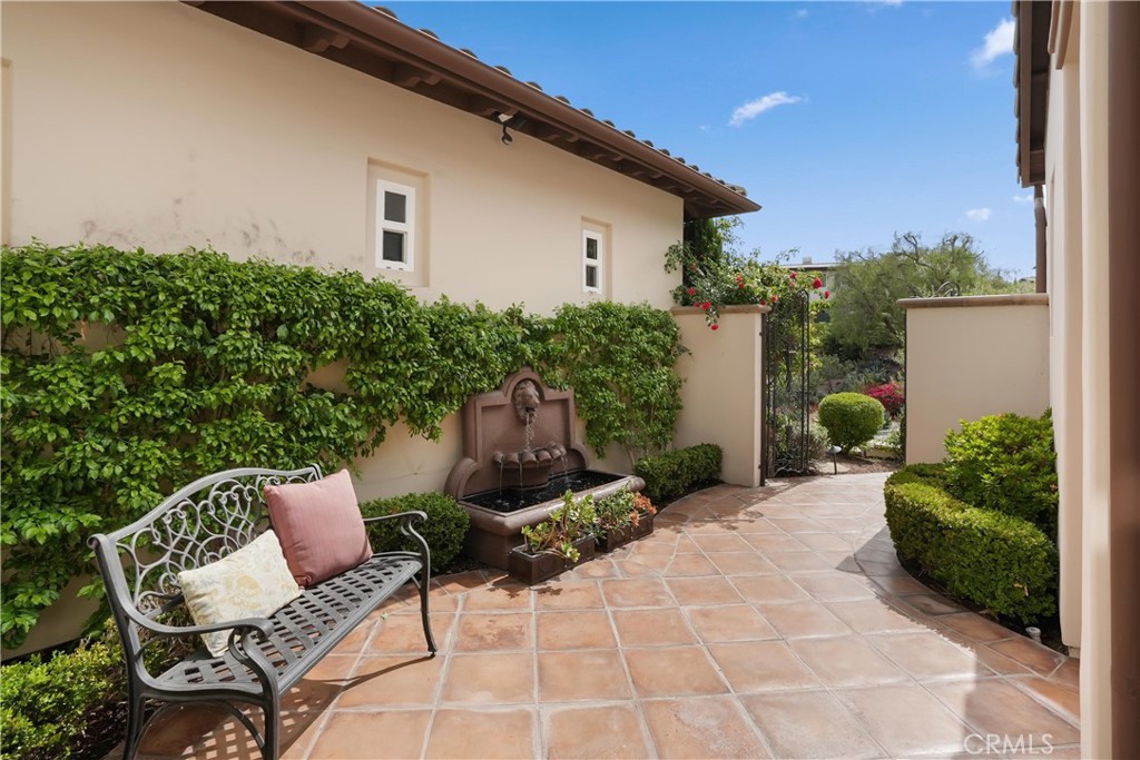 Private gated courtyard with tranquil fountain, decorative ironwork, and a welcoming outdoor sitting area. - 27532 Calle De La Rosa, San Juan Capistrano CA 92675 - photo 14