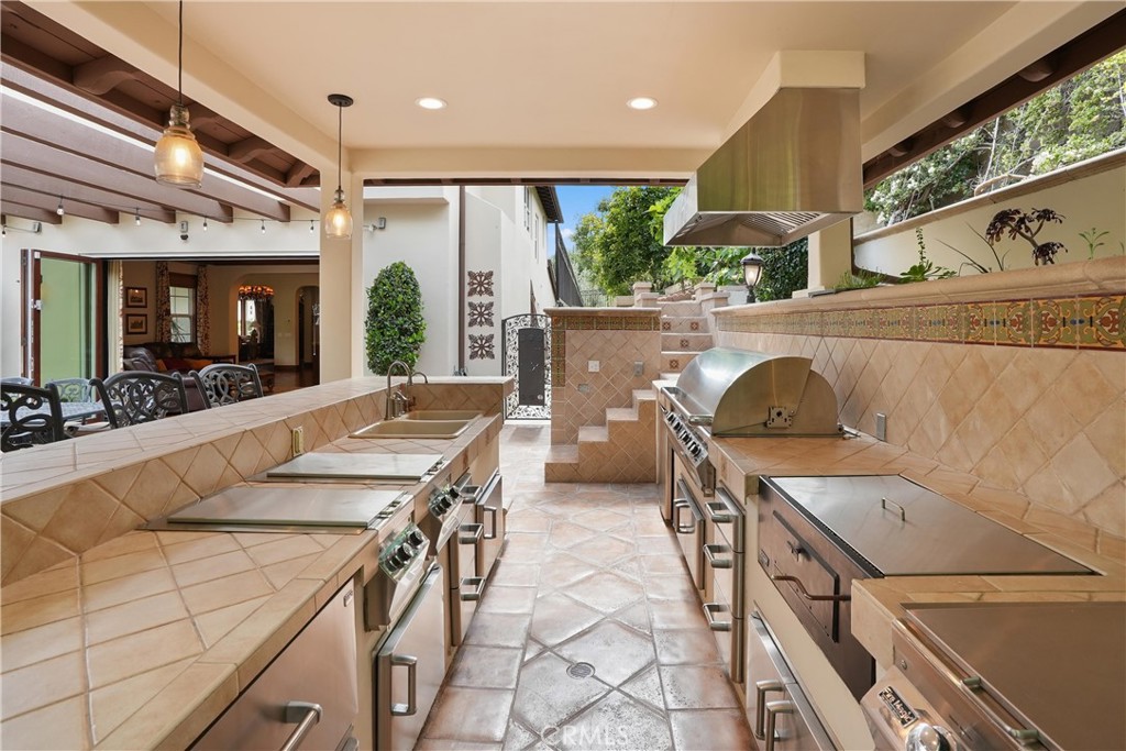Well-appointed outdoor kitchen designed for effortless entertaining with a built-in BBQ, refrigerator, and bar seating. - 27532 Calle De La Rosa, San Juan Capistrano CA 92675 - photo 33