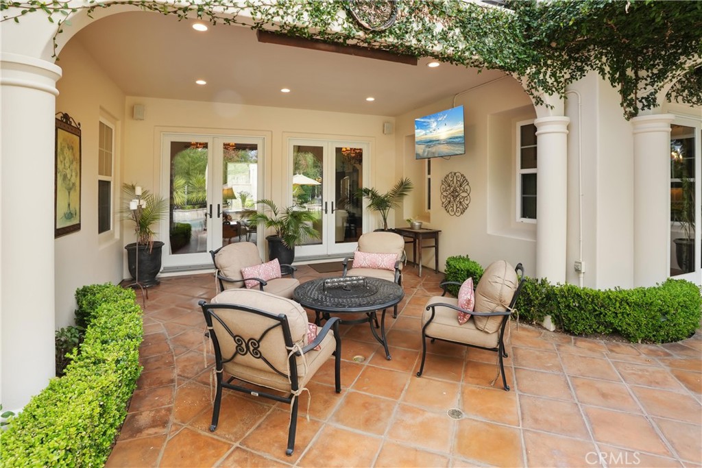 Covered outdoor living area designed for year-round enjoyment, featuring a built-in TV and comfortable seating. - 27532 Calle De La Rosa, San Juan Capistrano CA 92675 - photo 34