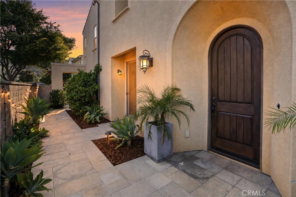 Inviting arched entry framed by mature landscaping and warm exterior lighting. - 28242 Camino Del Rio, San Juan Capistrano CA 92675 - photo 4