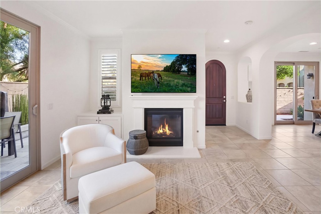 Bright family room featuring a fireplace, custom built-in cabinetry, recessed lighting, and direct access to the outdoor - 28242 Camino Del Rio, San Juan Capistrano CA 92675 - photo 6