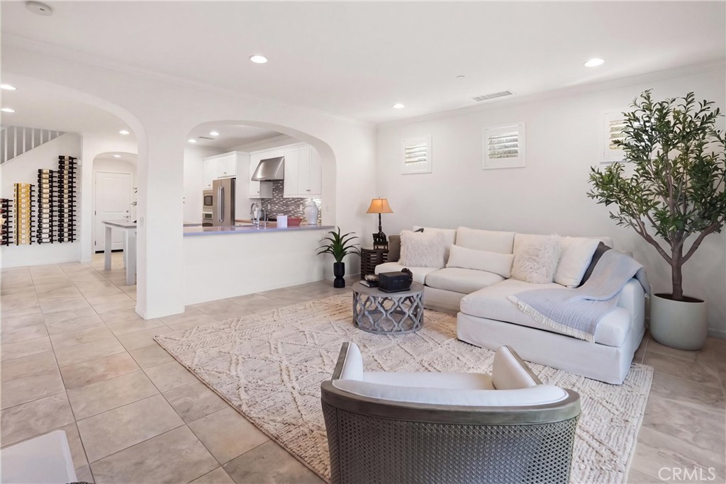 Open-concept family room with arched openings connecting the living space to the kitchen, creating an easy flow for ever - 28242 Camino Del Rio, San Juan Capistrano CA 92675 - photo 7