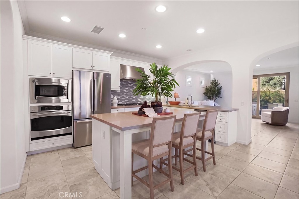 Another view of the kitchen highlighting the expansive center island, generous counter space, stainless steel appliances - 28242 Camino Del Rio, San Juan Capistrano CA 92675 - photo 10