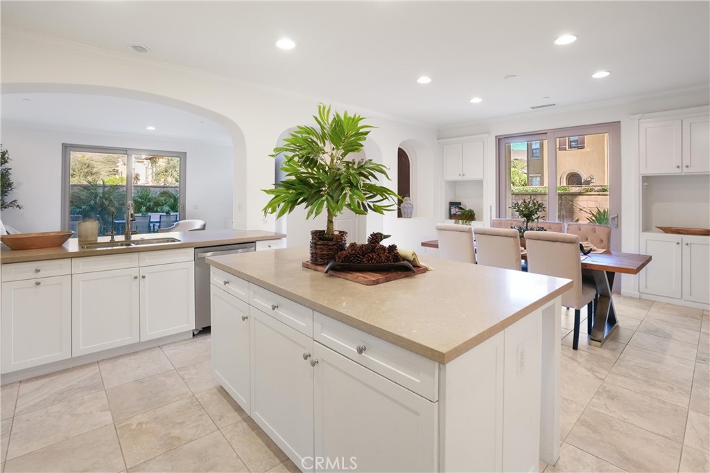 Open kitchen and dining area featuring white cabinetry, a large center island with generous storage, ample counter space - 28242 Camino Del Rio, San Juan Capistrano CA 92675 - photo 11