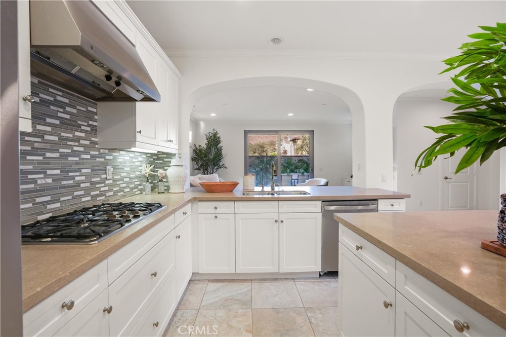 Kitchen view highlighting the gas cooktop, mosaic tile backsplash, extensive cabinetry, ample counter space, and an open - 28242 Camino Del Rio, San Juan Capistrano CA 92675 - photo 13