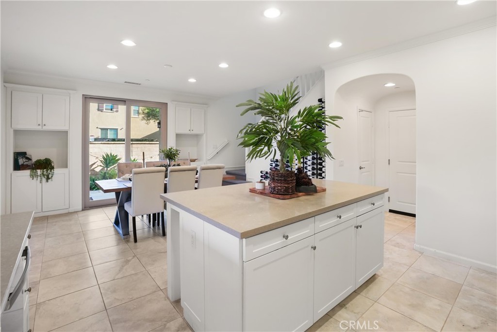 Spacious kitchen showcasing a large center island with abundant cabinetry and counter space, with the adjacent dining ar - 28242 Camino Del Rio, San Juan Capistrano CA 92675 - photo 14