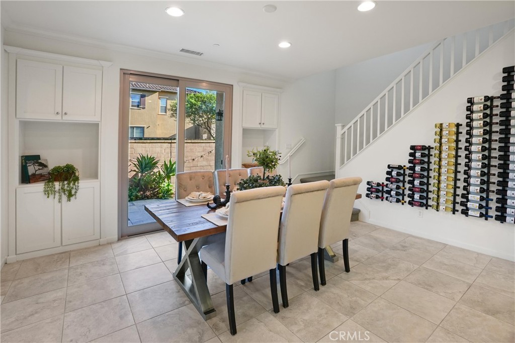 Dining area featuring built-in cabinetry, direct outdoor access, and a distinctive wall-mounted wine storage display ben - 28242 Camino Del Rio, San Juan Capistrano CA 92675 - photo 15