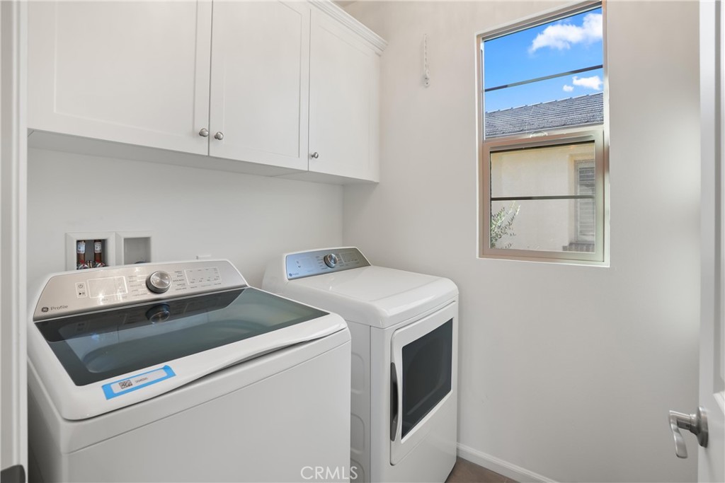 Dedicated laundry room located upstairs with upper cabinetry for convenient storage and a window providing natural light - 28242 Camino Del Rio, San Juan Capistrano CA 92675 - photo 22