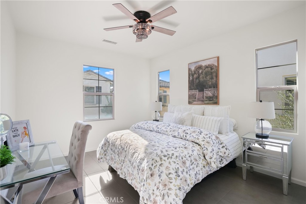 Bright secondary bedroom with multiple windows, ceiling fan, and space for a desk or additional furnishings. - 28242 Camino Del Rio, San Juan Capistrano CA 92675 - photo 26