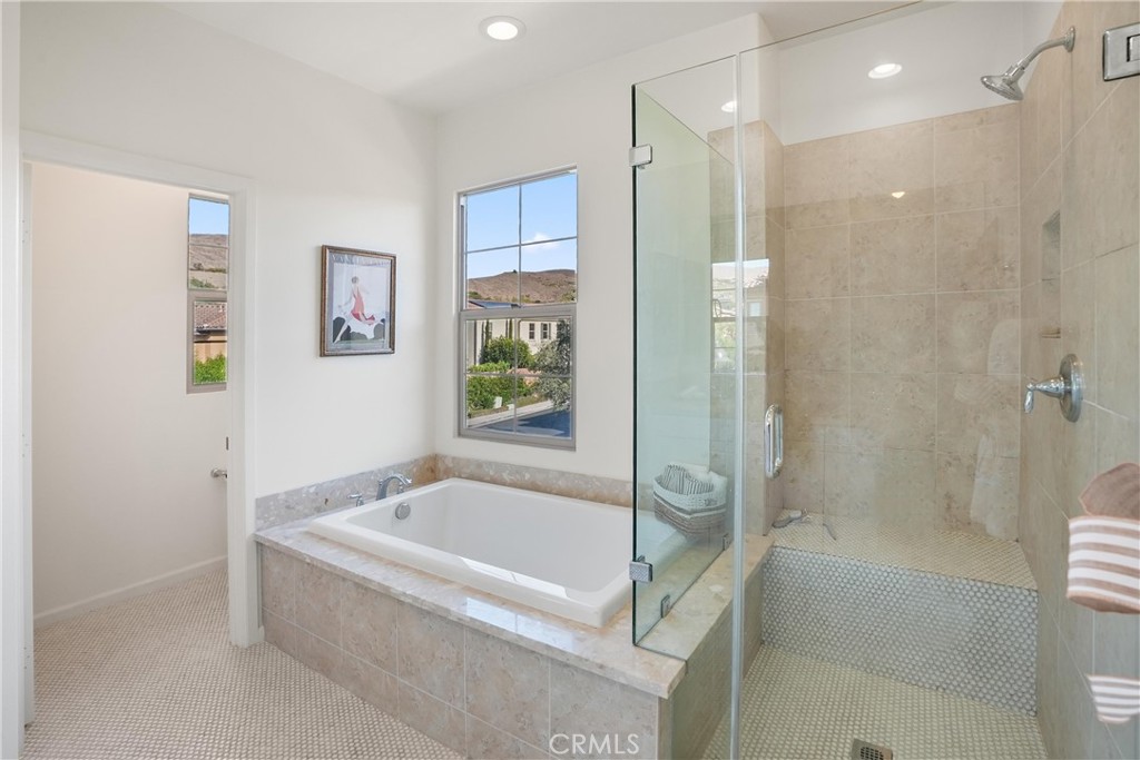 Primary bathroom featuring a soaking tub and separate glass enclosed walk in shower. - 28242 Camino Del Rio, San Juan Capistrano CA 92675 - photo 33