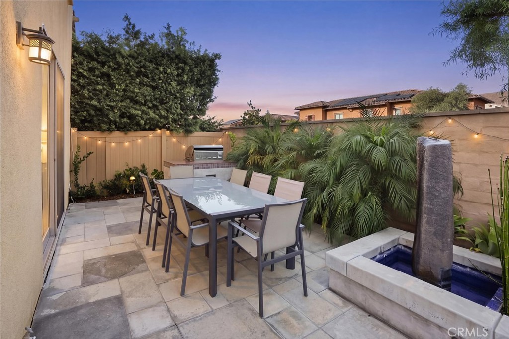 Private outdoor entertaining area featuring a built-in barbecue, custom fountain, lush landscaping, and generous space f - 28242 Camino Del Rio, San Juan Capistrano CA 92675 - photo 35