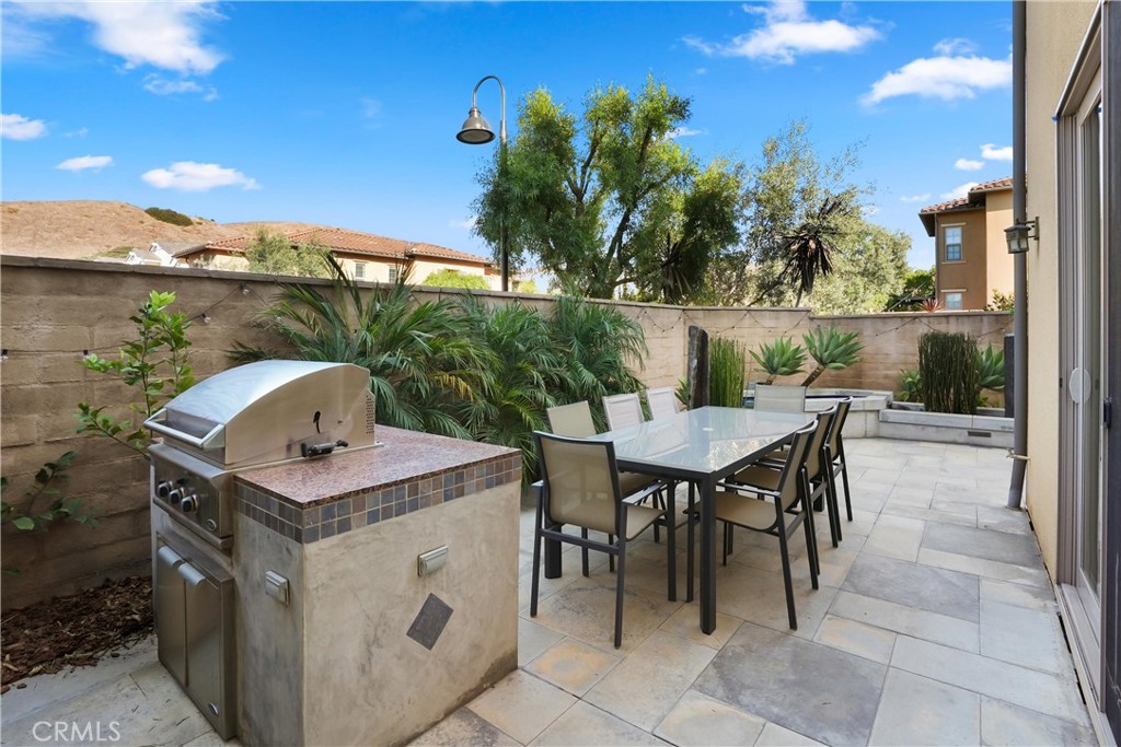 Private backyard patio with built in barbecue, outdoor dining space, and mature landscaping - 28242 Camino Del Rio, San Juan Capistrano CA 92675 - photo 37