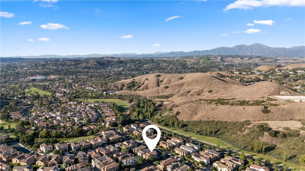 Expansive aerial perspective highlighting the home’s location with rolling hills and mountain views in the distance. - 28242 Camino Del Rio, San Juan Capistrano CA 92675 - photo 43