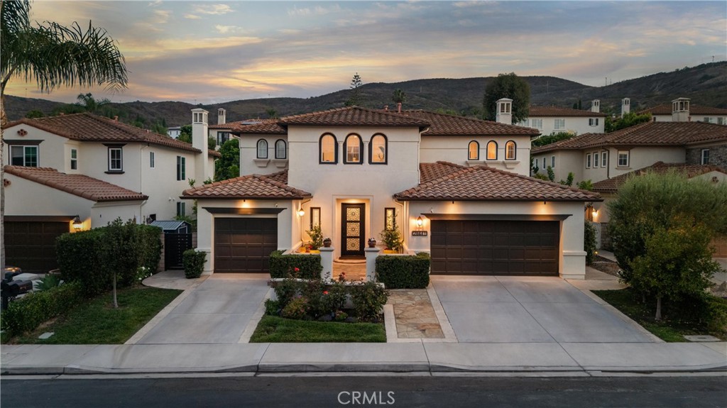 Mediterranean-style two-story home with stucco exterior, clay tile roof, three-car garage, arched windows, landscaped fr - 28441 Via Mondano, San Juan Capistrano CA 92675 - photo 1