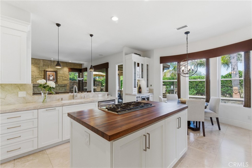 Remodeled kitchen featuring custom cabinetry, Taj Mahal quartzite countertops, stainless steel appliances, and a center - 31251 Calle Bolero, San Juan Capistrano CA 92675 - photo 16