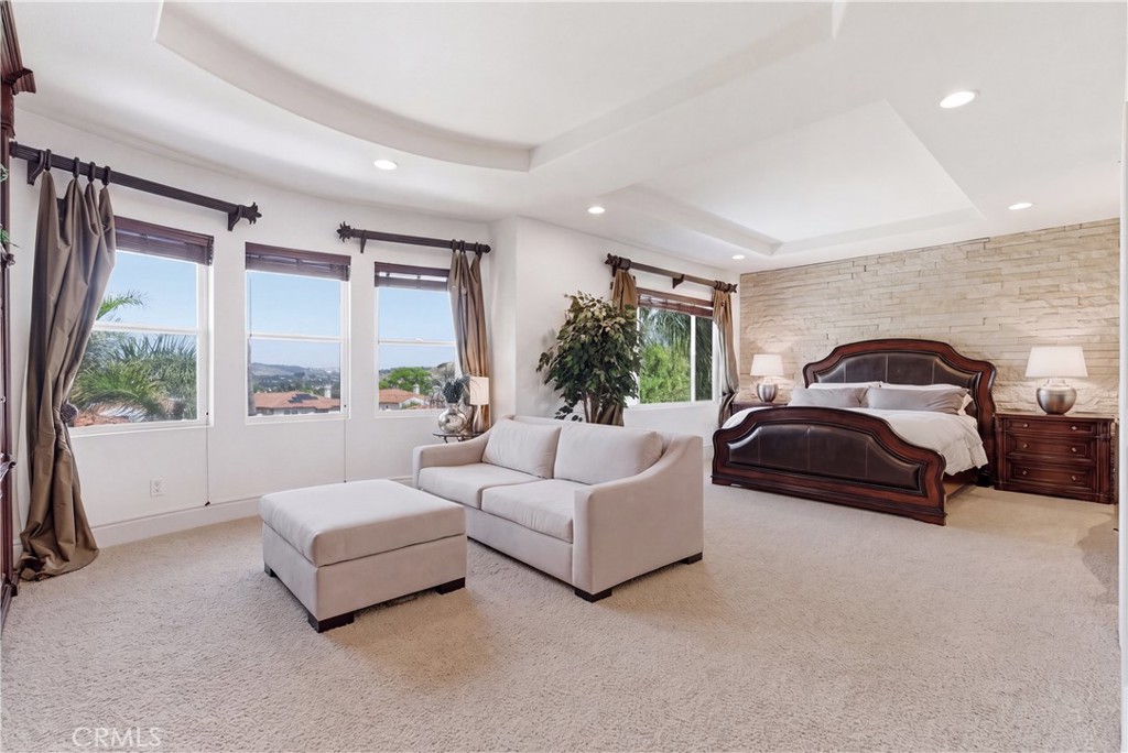 Spacious primary suite with a private sitting area, abundant natural light, and picturesque hillside and neighborhood vi - 31251 Calle Bolero, San Juan Capistrano CA 92675 - photo 24