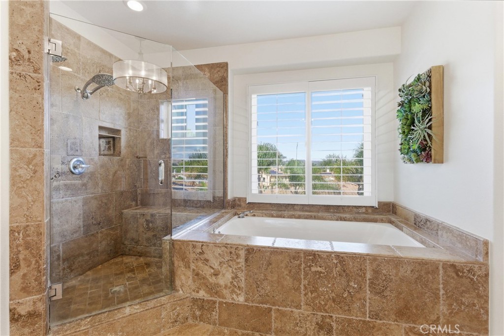 Spa-inspired primary bathroom with dual vanities, a soaking tub, and oversized walk-in shower - 31251 Calle Bolero, San Juan Capistrano CA 92675 - photo 32