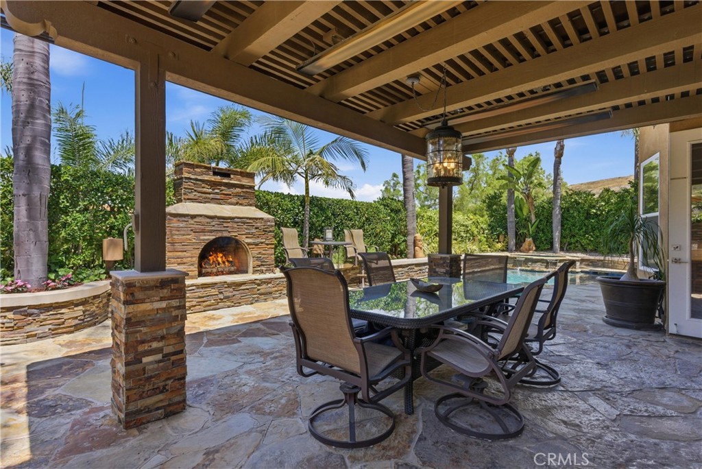 Covered outdoor entertaining area, a stone fireplace, and multiple seating spaces - 31251 Calle Bolero, San Juan Capistrano CA 92675 - photo 45