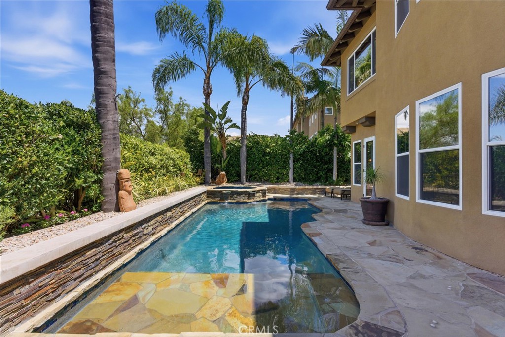 Resort-style backyard featuring a custom pool and spa, mature landscaping, and multiple areas for outdoor relaxation - 31251 Calle Bolero, San Juan Capistrano CA 92675 - photo 48