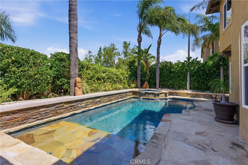 Resort-style backyard featuring a custom pool and spa, mature landscaping, and multiple areas for outdoor relaxation - 31251 Calle Bolero, San Juan Capistrano CA 92675 - photo 49