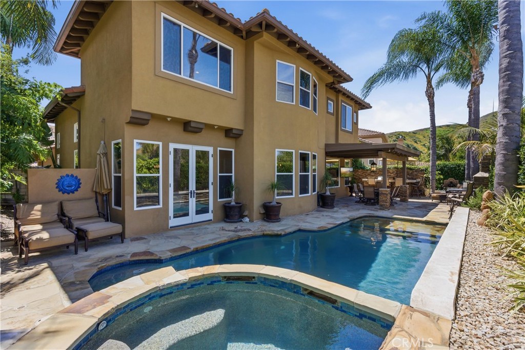 Resort-style backyard featuring a custom pool and spa, mature landscaping, and multiple areas for outdoor relaxation - 31251 Calle Bolero, San Juan Capistrano CA 92675 - photo 50