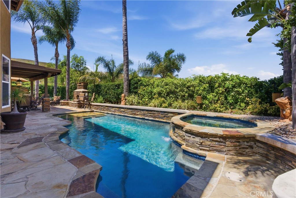 Resort-style backyard featuring a custom pool and spa, mature landscaping, and multiple areas for outdoor relaxation - 31251 Calle Bolero, San Juan Capistrano CA 92675 - photo 51