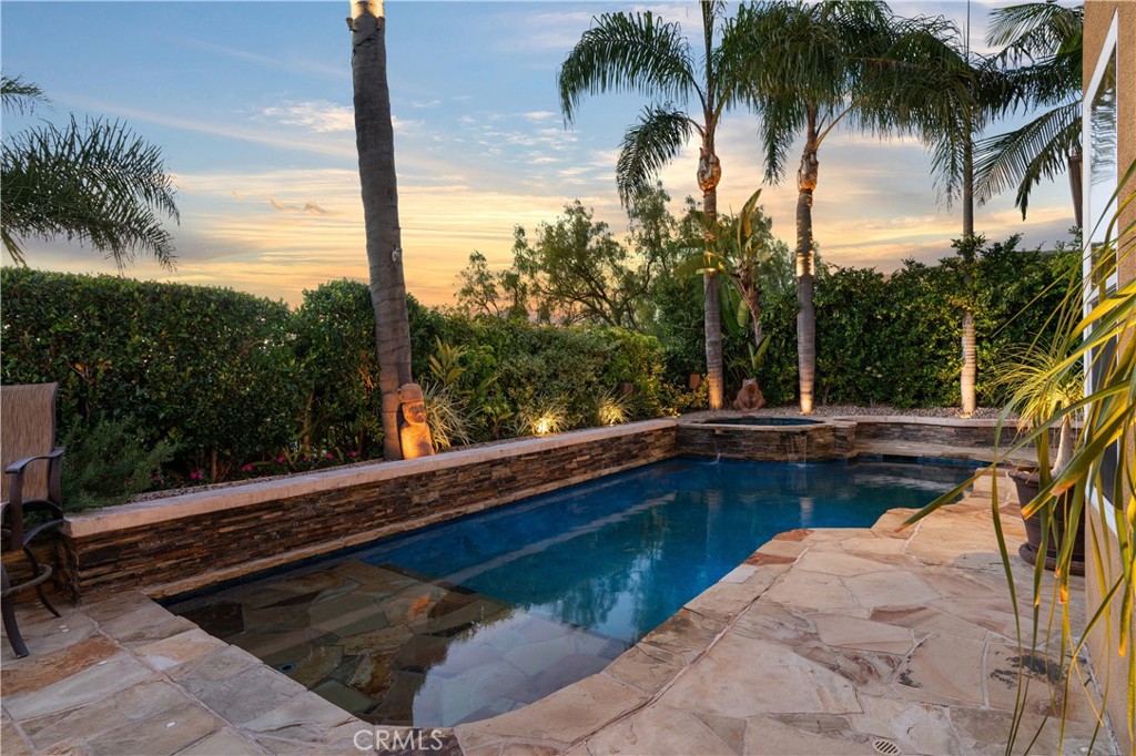 Resort-style backyard featuring a custom pool and spa, mature landscaping, and multiple areas for outdoor relaxation - 31251 Calle Bolero, San Juan Capistrano CA 92675 - photo 52