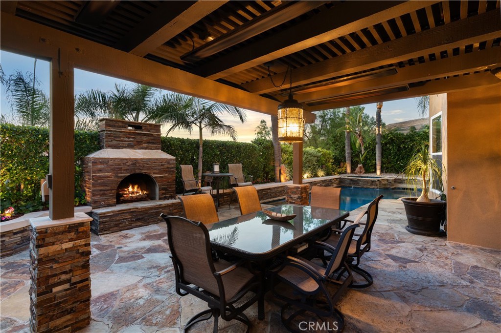 Covered outdoor entertaining area, a stone fireplace, and multiple seating spaces - 31251 Calle Bolero, San Juan Capistrano CA 92675 - photo 54
