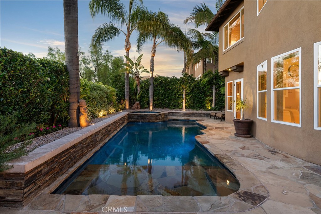 Resort-style backyard featuring a custom pool and spa, mature landscaping, and multiple areas for outdoor relaxation - 31251 Calle Bolero, San Juan Capistrano CA 92675 - photo 56