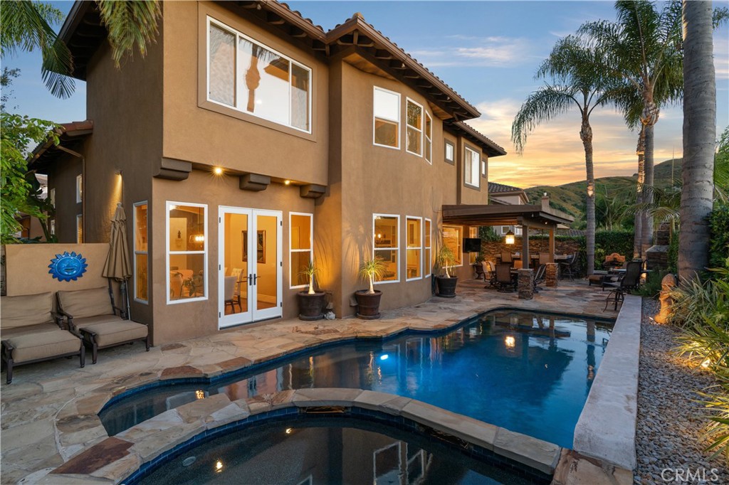 Resort-style backyard featuring a custom pool and spa, mature landscaping, and multiple areas for outdoor relaxation - 31251 Calle Bolero, San Juan Capistrano CA 92675 - photo 57