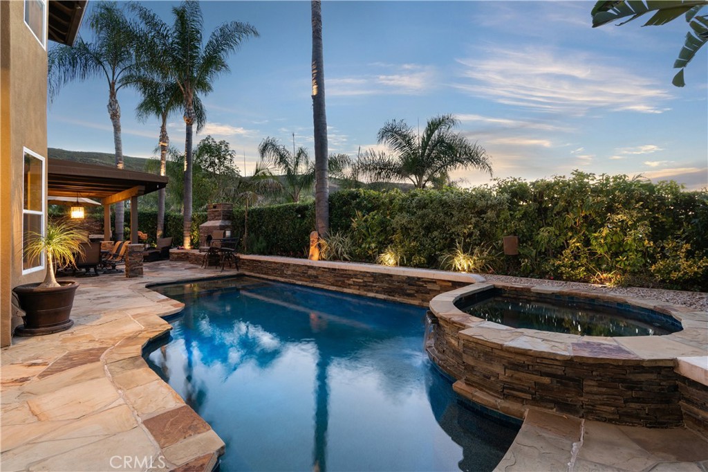 Resort-style backyard featuring a custom pool and spa, mature landscaping, and multiple areas for outdoor relaxation - 31251 Calle Bolero, San Juan Capistrano CA 92675 - photo 58