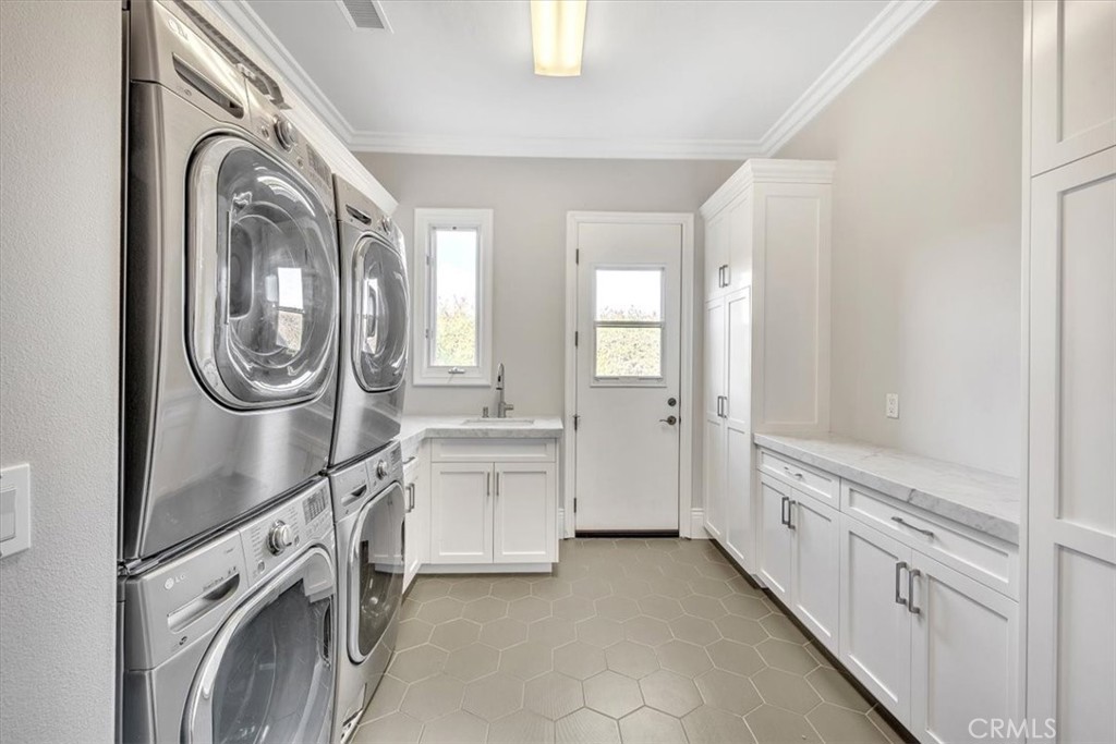 Laundry room includes cabinets and folding counters with door to the garden. - 31378 Juliana Farms Road, San Juan Capistrano CA 92675 - photo 25
