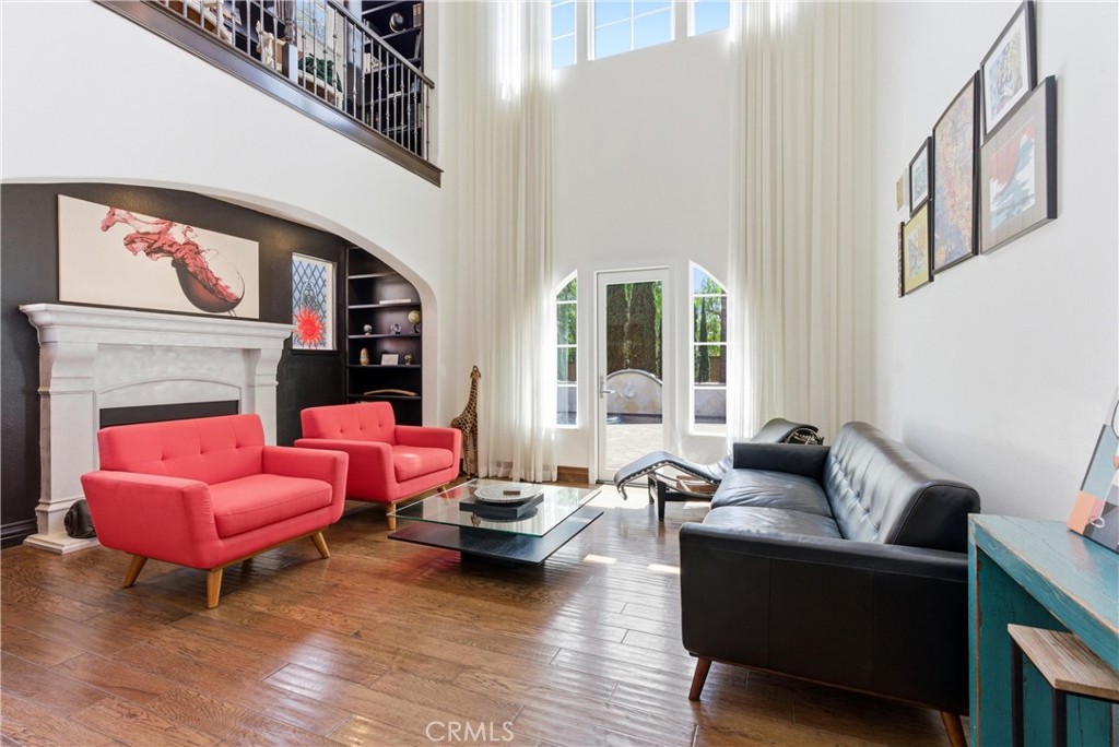 Dramatic two-story living room with floor-to-ceiling windows, abundant natural light, custom drapery, hardwood flooring, - 31491 Carril De Maderas, San Juan Capistrano CA 92675 - photo 6