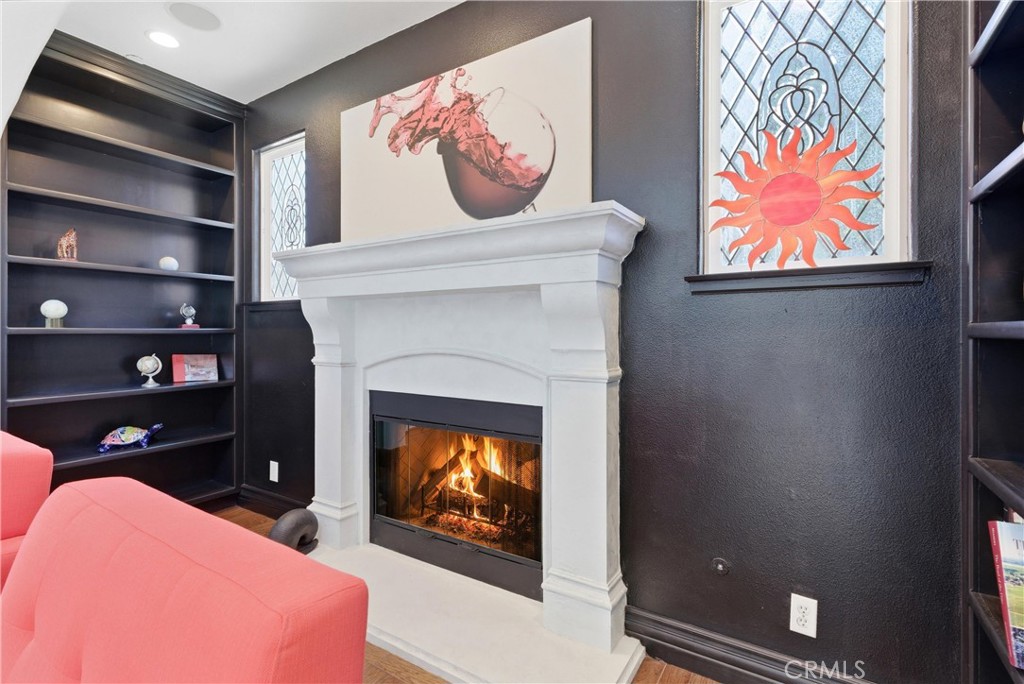 Designer fireplace detail with custom mantel, black accent walls, built-in shelving, leaded glass windows, and warm cont - 31491 Carril De Maderas, San Juan Capistrano CA 92675 - photo 8