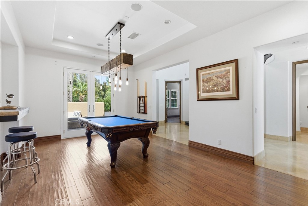 Spacious recreation room with pool table, custom lighting, French doors to the outdoor entertaining area, and seamless c - 31491 Carril De Maderas, San Juan Capistrano CA 92675 - photo 13