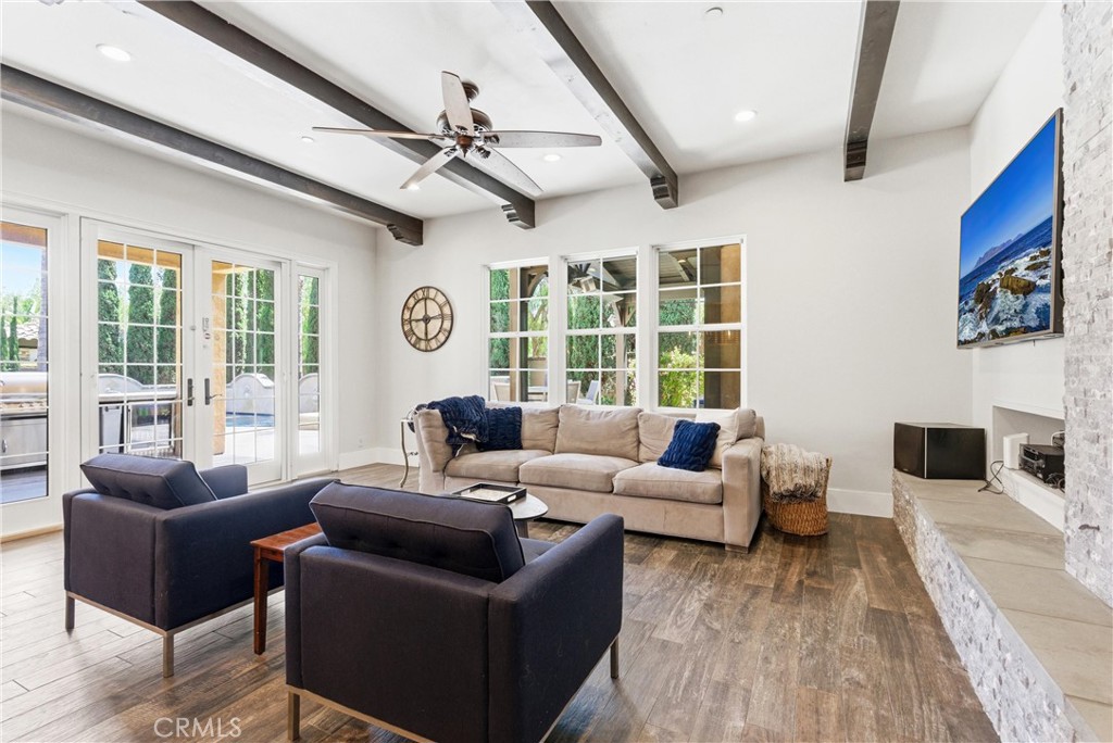 Fully remodeled family room with exposed beam ceilings, stacked-stone fireplace, wide-plank flooring, oversized windows, - 31491 Carril De Maderas, San Juan Capistrano CA 92675 - photo 15