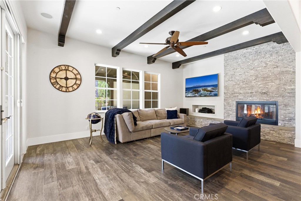 Designer great room featuring exposed wood beams, modern fireplace, custom built-ins, and open flow to the chef’s kitche - 31491 Carril De Maderas, San Juan Capistrano CA 92675 - photo 16